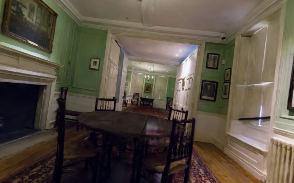 Inside a Georgian townhouse: green panelled rooms, a fireplace and a table with chairs